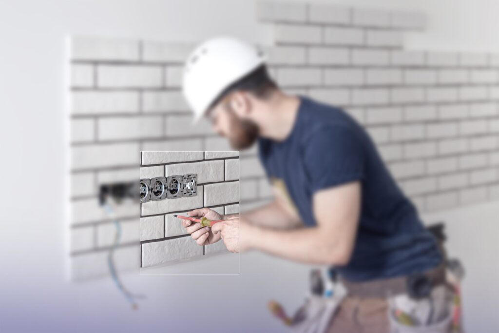 Elektriker der Xhoxhaj Gruppe verkabelt eine Unterputzdose für die Ladeinfrastruktur