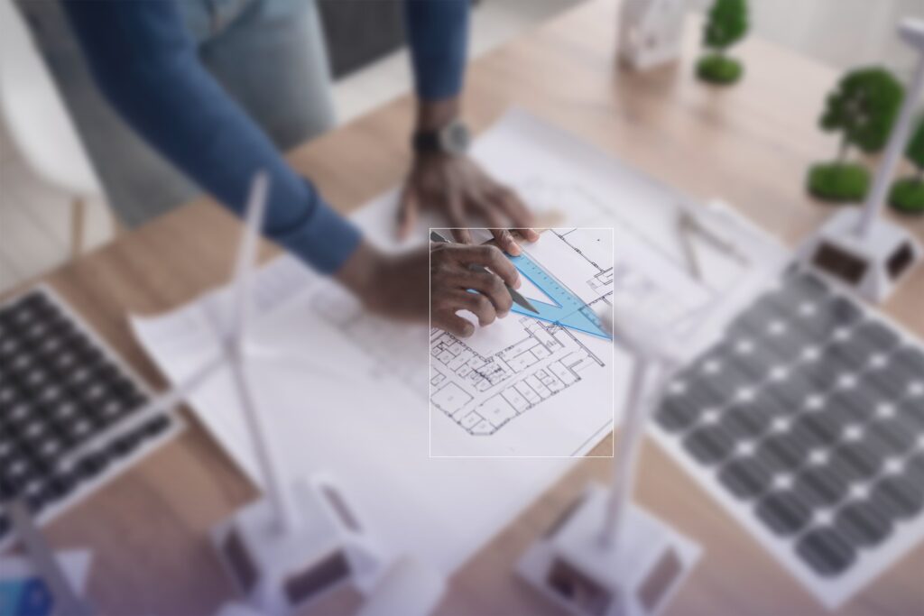 Bauplan mit Modell einer Photovoltaikanlage und Windrad auf dem Tisch der Energieberatung