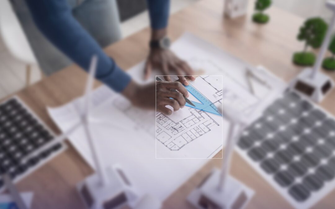 Bauplan mit Modell einer Photovoltaikanlage und Windrad auf dem Tisch der Energieberatung
